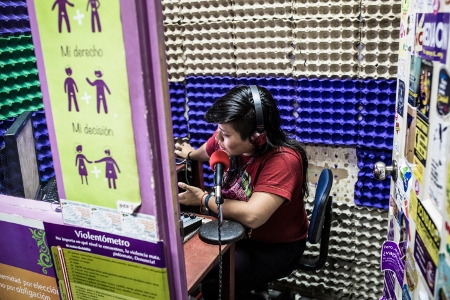 Joselin Garcia sänder för Collectiva Feministas egen radiokanal. På väggen går det bland annat att läsa ”min sexualitet, min rätt, mitt val.” 