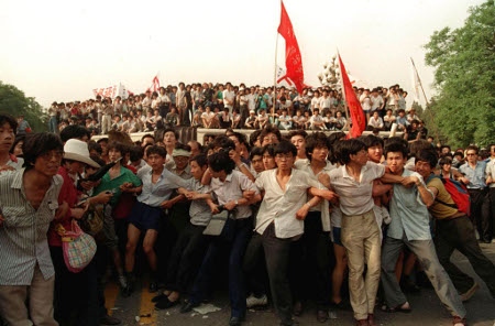 Demokratidemonstranter i Peking skyddar soldater den 3 juni 1989 från en uppretad folkmassa. 
