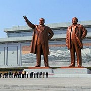 Nordkoreaner bugar framför statyer av Kim Il-sung och Kim Jong-il vid Mansudae-monumentet. 