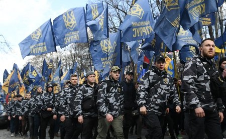 Medlemmar i partiet Nationella kåren deltar i en högernationalistisk marsch i Kiev den 3 april för ”Ett framtida Ukraina utan oligarker”. Kärnan i partiet kommer från Azov-bataljonen, en nazistisk frivilligmilis som bekämpade separatisterna i östra Ukraina innan de integrerades i ukrainska armén.