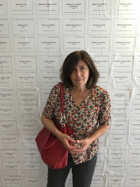 Elisabetta Canitano framför väggen där namnen på alla kvinnor som mördats under 2017 i Italien finns med. Där står också hur de mördades och vem som mördade dem, vilket ofta är en närstående man.