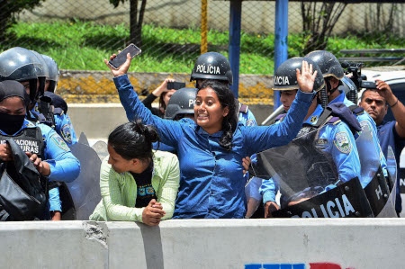 Lärare, studenter och läkare har protesterat i Honduras de senaste månaderna mot privatiseringar av undervisning och hälsovård. Här grips två lärarstudenter den 12 juni.