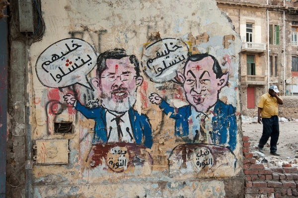 Graffiti längs gatan Mohamed Mahmoud. Före revolutionen säger ex-president Mubarak ”låt dem ha roligt”. Efter revolutionen säger president Mursi ”låt dem förlamas”.
