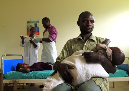 Familjeplanering i Uganda. Twesigye Christente väntar på att få preventivmedel på en hälsoklinik i Kinaaba i Uganda medan maken håller parets yngsta barn.