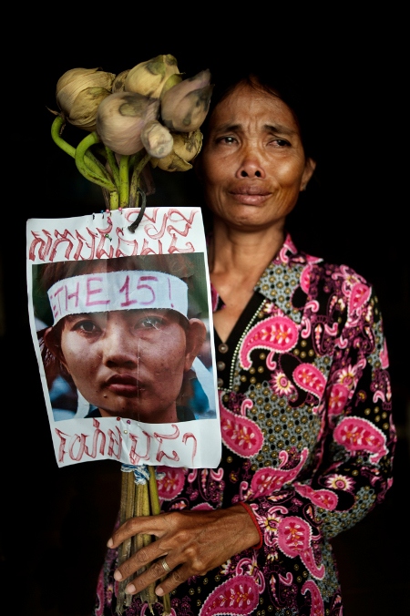 Sombo Sut, 60, håller upp en bild på sin dotter Yorm Bopha.