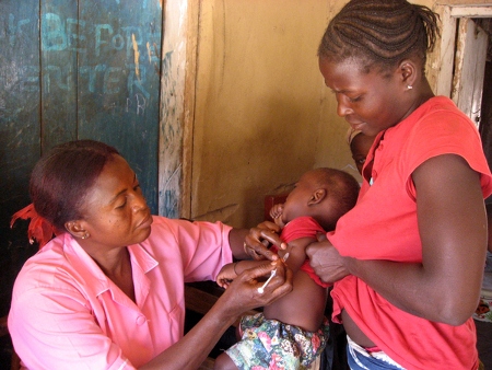En hälsovårdsarbetare i en by i norra Sierra Leone ger en vaccination i februari 2009. Då hade hon inte fått lön av regeringen på fyra år.