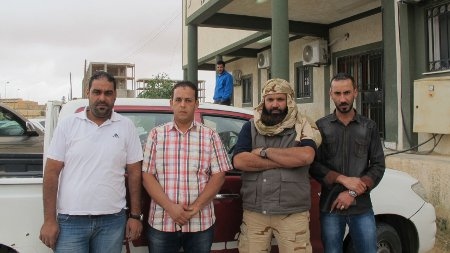 Den lokale milisledaren Ziad Zabala (med skägg) tillsammans med tre poliser utanför polisstationen i staden Jadu - en av många platser i Libyen där de lokala milisgruppernas makt är mycket stor.