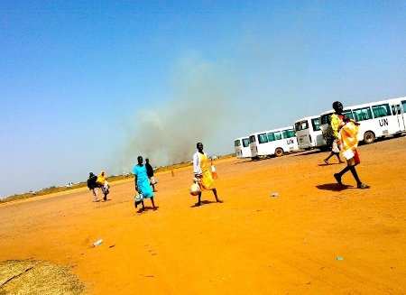 Många flydde undan striderna, som inleddes den 15 december, genom att ta sig över flygplatsen mot FN-basen. I bakgrunden stiger rök, endast någon kilometer bort, antagligen från SPLA's militärbas Bilpam, som blev attackerad under natten. 