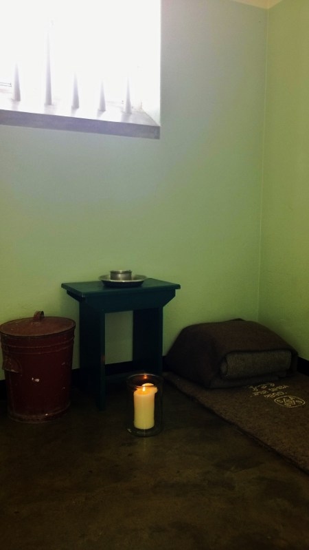 Ett ljus är tänt i Nelson Mandelas cell på Robben Island, detta är dagarna efter Mandelas bortgång i december 2013.