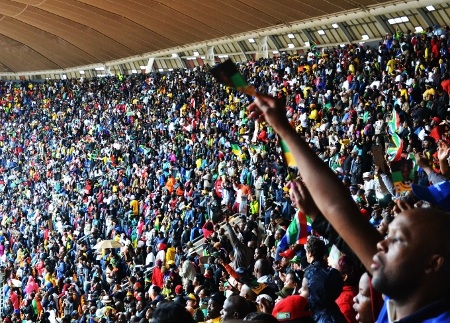 Människor sjunger om Mandela och ANC på Mandelas minnesceremoni på FNB stadium.
