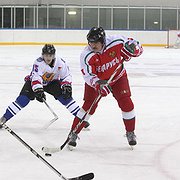 President Lukasjenko (till höger) har pucken under en match den 29 december 2013. Presidentens lag vann med 8-2 mot laget från Mogilev Oblast.
