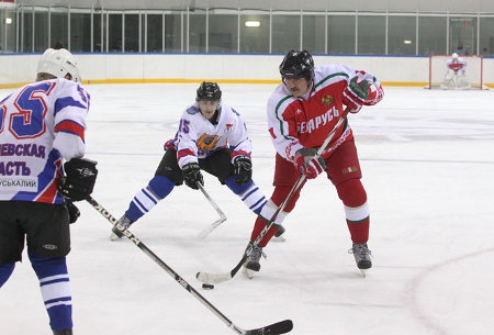 President Lukasjenko (till höger) har pucken under en match den 29 december 2013. Presidentens lag vann med 8-2 mot laget från Mogilev Oblast.