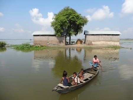 Familjer i det översvämningsdrabbade Assam tvingas använda båtar för att ta sig från sina hem.