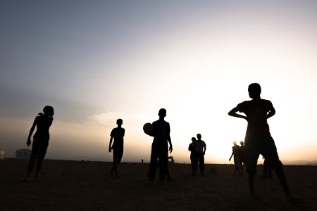Flyktingbarn spelar fotboll till sent på kvällen i flyktinglägret