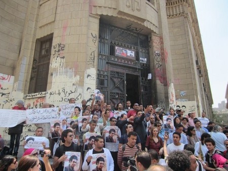 Egyptiska ungdomsaktivister i en protestaktion utanför en domstolslokal i maj 2013. Efter att militären tog makten sommaren 2013 har tusentals personer fängslats av politiska skäl.