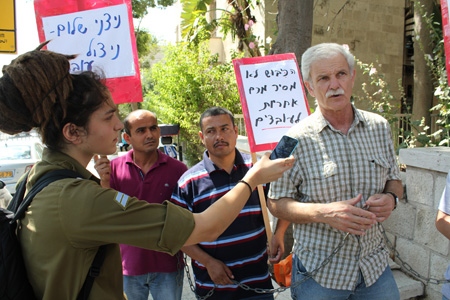 Den israeliska fackföreningen WAC-MAAN: s generalsekreterare Assaf Adiv intervjuas av israelisk radio under en demonstration i Jerusalem mot exploateringen av palestinska arbetare på israeliska bosättningar på Västbanken. 