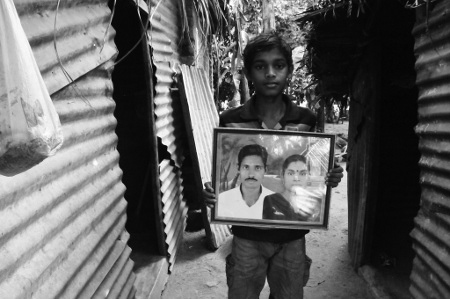 Jadusan Utharai, 14, med ett foto på sina föräldrar. Hans pappa har varit försvunnen sedan mars 2009.