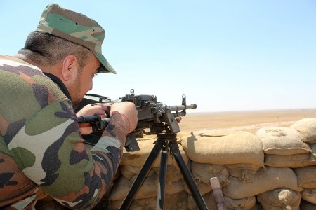 En yazidisk peshmerga-soldat poserar vid frontlinjen mot de IS-kontrollerade områdena i södra Sinjar. 