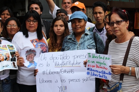 Carolina Sojo med foto av sin make utanför domstolsbyggnaden i Caracas.