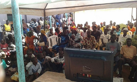 Invånare i Ludoki i norra Uganda följer öppnandet av rättegången mot Dominic Ongwen den 6 december. 