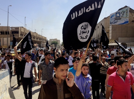 Anhängare till IS framför provinsguvernörens högkvarter i Mosul i Irak i juni 2014 när IS hade intagit staden och ett kalifat utropades.