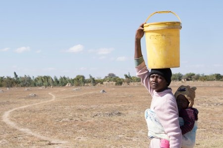 Charity Ncube från Masvingo i Zimbabwe har hämtat vatten i sin 20 liter stora tunna.