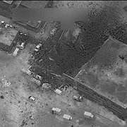 Flygbild över det bombade området i al-Jinah som USA:s försvarsdepartement presenterade den 17 mars. Inne i den förstörda byggnaden dog minst 38 personer. Till vänster på bilden syns en moské som är oskadad.