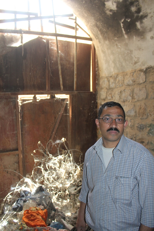 Mofeed al-Sharabati framför galler stålgrinden som hindrar honom från att besöka sitt hus i Hebron. Familjen flydde från huset när bosättare gick bärsärk i Hebron år 2002. Trots att Israels Högsta domstol slog fast att familjen har rätt till huset 2005 hindras de av armén från att flytta in.