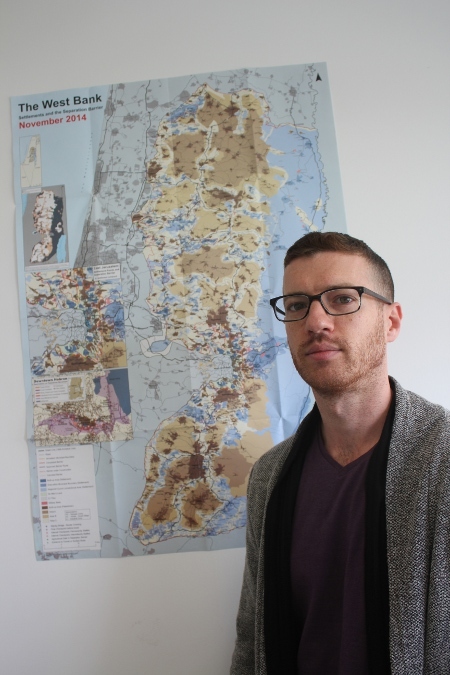 Amit Gilutz, talesperson för den israeliska människorättsorganisationen B'Tselem framför en karta över Västbanken.