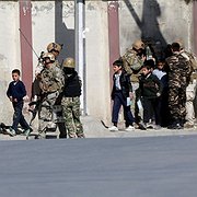  Säkerhetsstyrkor skyddar skolbarn i samband med attacken mot TV-stationen Shamshad TV i huvudstaden Kabul den 7 november. Två personer dödades vid attacken som IS, Islamiska staten, tog på sig.
