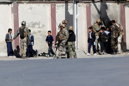  Säkerhetsstyrkor skyddar skolbarn i samband med attacken mot TV-stationen Shamshad TV i huvudstaden Kabul den 7 november. Två personer dödades vid attacken som IS, Islamiska staten, tog på sig.