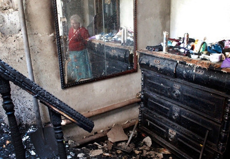 Kriget i östra Ukraina har drabbat civila hårt på bägge sidor. Här en kvinna i ett förstört hem i Donetsk i början av 2015.