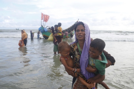 Rohingyaflyktingar anländer med båt efter att ha tagit sig över floden Naf, som skiljer Bangladesh och Burma åt.