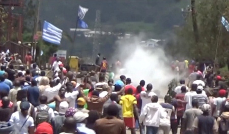 Med flaggan för ”Ambazonia” går demonstranter i Bamenda i västra Kamerun den 1 oktober mot polisens barrikader och tårgas. 