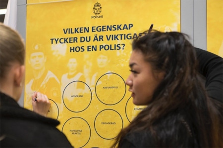 På utsidan av Polismyndighetens monter samlas några besökare för att välja ut några egenskaper man anser viktiga hos polisen.