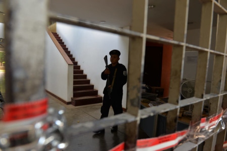  En polis vaktar den numera stängda byggnad där tidskriften Confidencial och andra medier som ägs av Carlos Fernando Chamorro tidigare huserade. Tillslaget genomfördes den 14 december 2018.