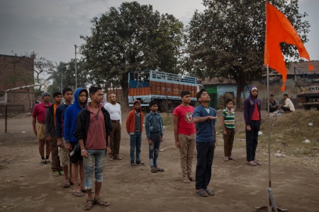 Unga pojkar från den hinduiska extremistorganisationen RSS hissar den flagga som är symbolen för den hinduiska rörelsen.