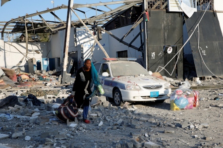 En kvinna samlar ihop sina ägodelar i förvaret Tajoura utanför Libyens huvudstad Tripoli efter flyganfallet natten till 3 juli.