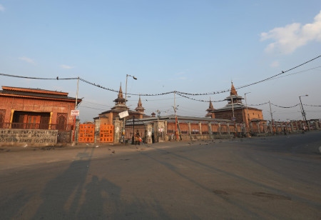 En soldat vaktar utanför Kashmirs största moské, Jamia Masjid. Sedan den 5 augusti har inga bönestunder tillåtits i moskén.