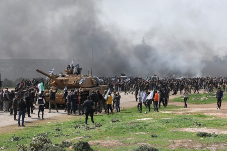 En turkisk stridsvagn omringad under en protest på M4-vägen den 15 mars där Turkiet och Ryssland gemensamt ska patrullera enligt vapenvilan i Idlib.