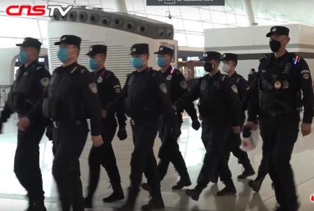 Poliser i ansiktsmask patrullerar på Wuhan Tianhe-flygplatsen den 22 januari.
