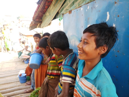 Mohammad Rafique (till höger) och andra flyktingbarn har samlats vid rohingyamarknaden i Kutupalong-lägret för att sälja grönsaker som han tagit med sig från en lokal marknad. Fotot är taget två veckor innan samhället stängdes ner för att hindra spridningen av coronaviruset.