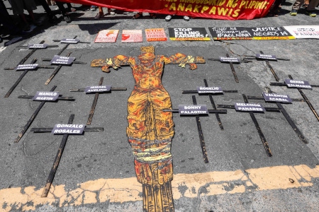  14 kors utanför polisens nationella högkvarter i Quezon City. Den 30 mars 2019 dödades 14 bönder på ön Negros. Myndigheterna hävdar att bönderna dog när militären sökte efter vapen från NPA-gerillan. 