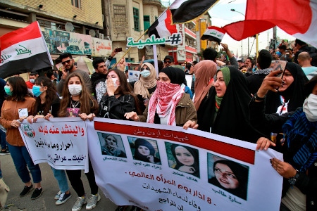  Kvinnor håller upp bilder på kvinnliga demonstranter som dödats under demonstrationer vid en demonstration i Bagdad den 1 mars 2020.