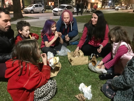 Familjen Binkle Sayavedra äter takeaway-middag på en gräsmatta med vänner, i strid med utegångsförbudet. 