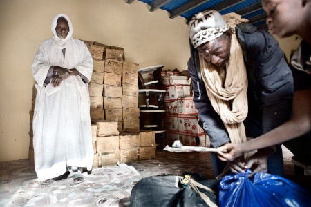 Grossisten Mohammed din Magia ser på när hans bror och brorson packar väskan för att resa till en by utanför Timbuktu.
