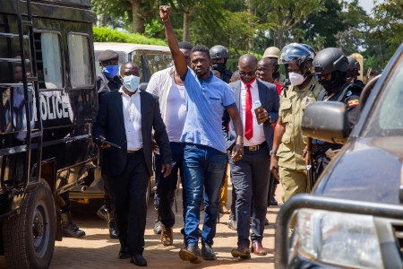 Bobi Wine (med knuten näve) förs till en domstol i Inganga i Uganda den 19 november.