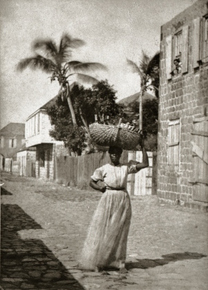 Gatubild från Gustavia någon gång mellan 1865-1880. Ett barn tittar ut från ett fönster.