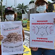 Demonstranter protesterar utanför parlamentet i Jakarta mot att den nya brottsbalken kontrollerar kvinnors kroppar.