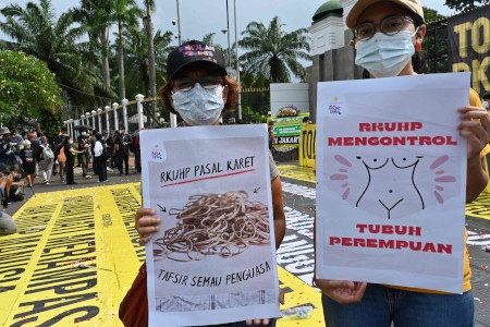 Demonstranter protesterar utanför parlamentet i Jakarta mot att den nya brottsbalken kontrollerar kvinnors kroppar.
